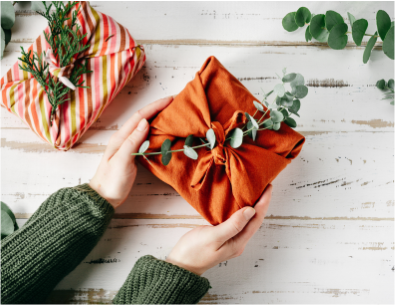 Close up of hands holding a present wrapped in cloth