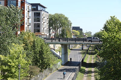 midtown greenway bikers, bridge and apartment buildings